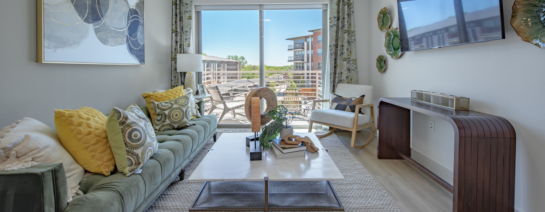 Apartment interior. Living area, including a couch, coffee table, TV, and entertainment content.