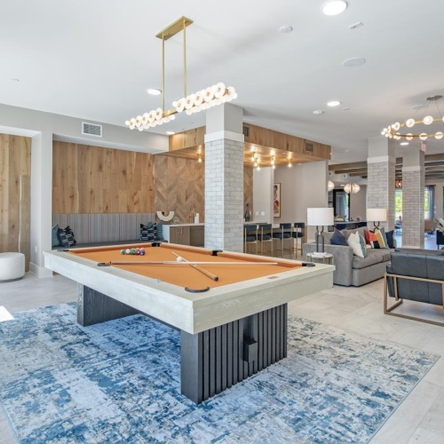 a large room with a pool table and chairs