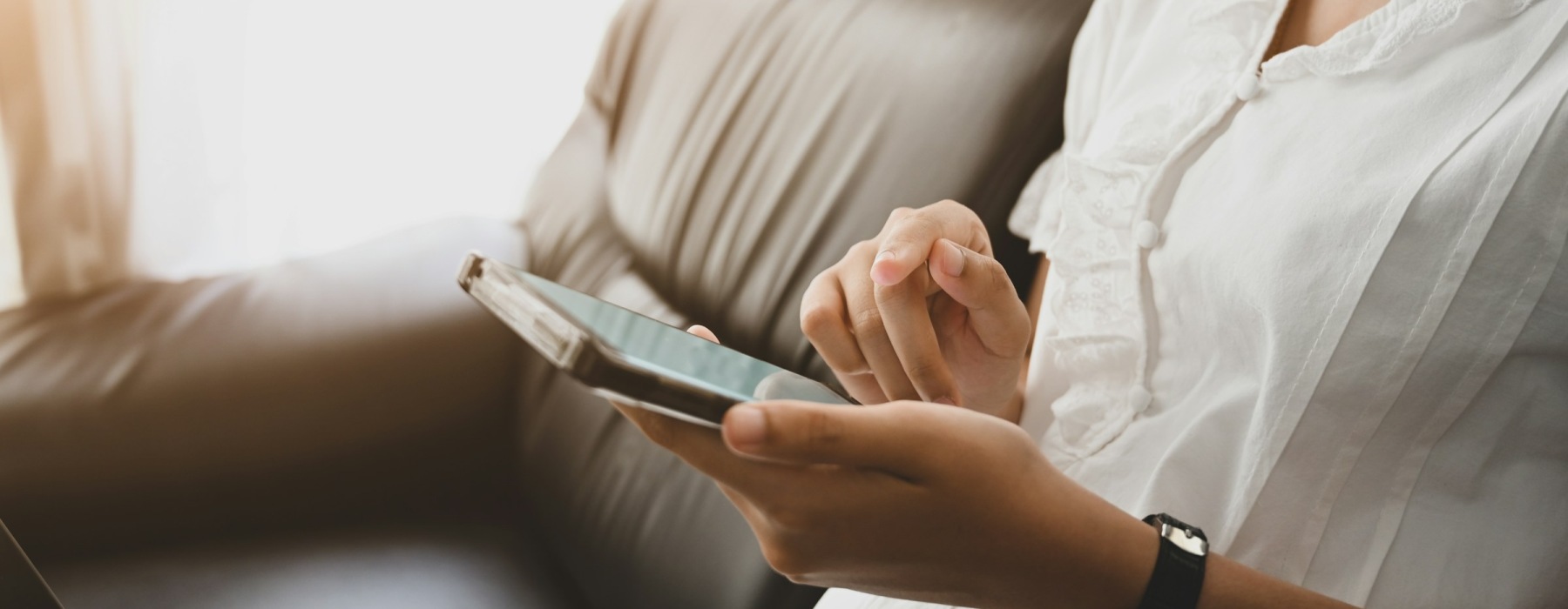 Person holding phone, finger hovering over screen.