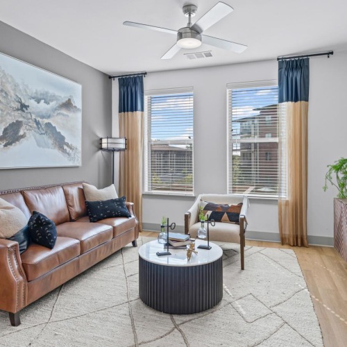 a living room with a couch and a tv and windows
